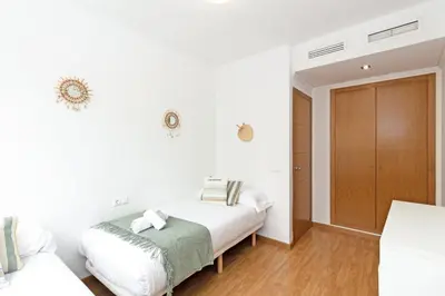a white bedroom with a bed and a wooden door at GuestReady - Lovely home near the beach in Valencia