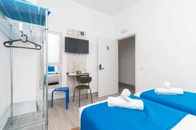 a hotel room with two beds and a bathroom at Moreno Rooms by BET Apartments in Valencia