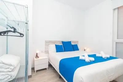 a bedroom with a bed with blue and white pillows at Moreno Rooms by BET Apartments in Valencia