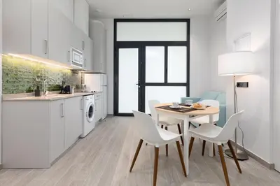a kitchen and dining room with a table and chairs at Apartamento 1º nuevo cerca playa in Valencia