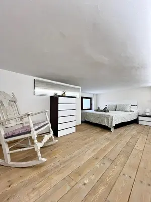 a bedroom with two beds and a rocking chair at Encanto Rural en Requena in Requena