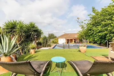 a yard with chairs and a table and a pool at Les moreres a space for tranquility in Valencia
