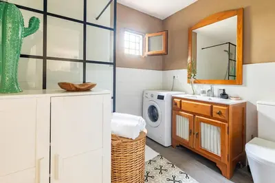 a bathroom with a sink and a washing machine at Les moreres a space for tranquility in Valencia
