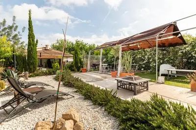 a garden with a patio with a table and chairs at Les moreres a space for tranquility in Valencia