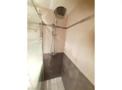 a shower with a shower head in a bathroom at Charming apt by the beach with stunning harbor views in Port Saplaya