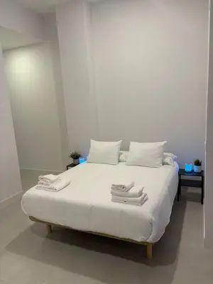 a white bed with white pillows and towels on it at Centric Loft near Arts & Science in Valencia
