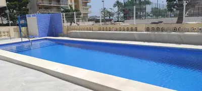 a large blue swimming pool in a building at Cisne! Vistas al mar, piscina y garaje in Cullera