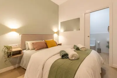 a bedroom with a large bed with towels on it at Paradise Suite - Cómodo y acogedor - Conectado con Aeropuerto, Playa y Centro in Valencia