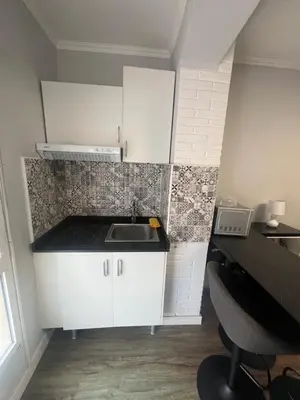a kitchen with white cabinets and a sink at Precioso estudio en la playa norte de Valencia in Puebla de Farnals