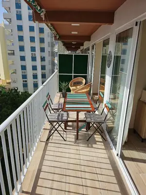 a deck with a table and chairs on a balcony at Coqueto apartamento en la playa in Puebla de Farnals