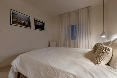 a white bed in a white bedroom with a window at Casa Roka in Alberique