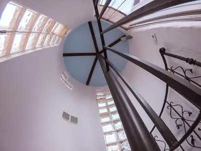 a spiral staircase in a building with a window at Casa de piedra en el casco antiguo de Sagunto in Sagunto
