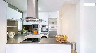 a large kitchen with white counters and appliances at Casa Calma - Modern Apartment, Perfect Location - All you need for a great time in Valencia in Valencia