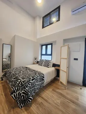 a bedroom with a black and white bed and a mirror at kala-mar Valencia in Valencia
