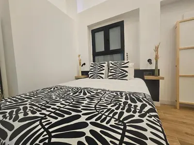 a bedroom with a black and white bed with two pillows at kala-mar Valencia in Valencia