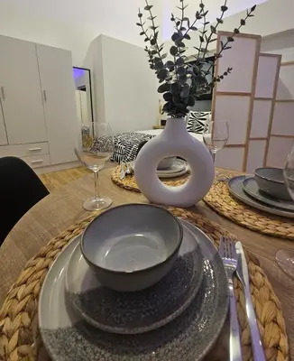 a table with a plate and a vase with a bowl at kala-mar Valencia in Valencia