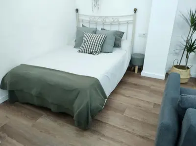 a bedroom with a large bed with blue pillows at District Key - Valencia, Plaza del Cedro in Valencia