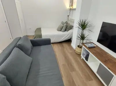 a living room with a couch and a television at District Key - Valencia, Plaza del Cedro in Valencia