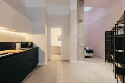 a kitchen with black and white cabinets and a room at Chic & Cozy Stay in Valencia in Valencia
