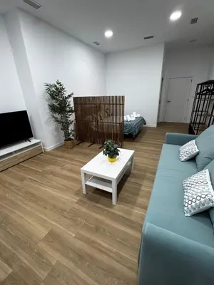 a living room with a blue couch and a table at Apartamento playa malvarrosa in Valencia