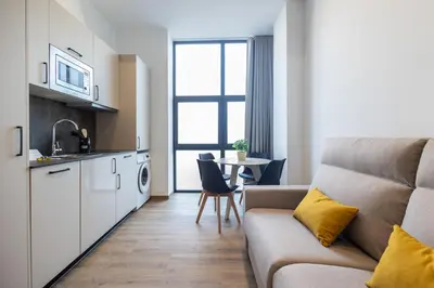 a living room with a couch and a kitchen at Les Arts Turia by Concept Flats in Valencia