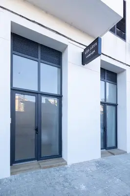a white building with large windows and a door at Les Arts Plaza by Concept Flats in Valencia