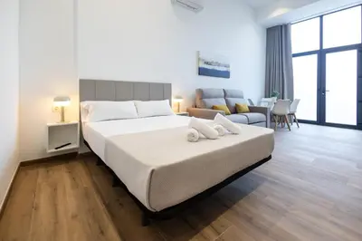 a bedroom with a large bed and a living room at Les Arts Plaza by Concept Flats in Valencia