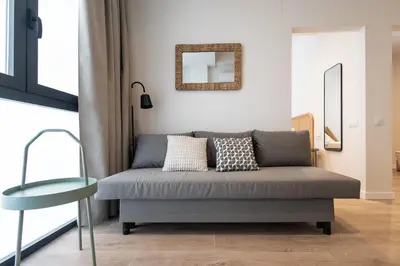 a grey couch in a living room with a mirror at Lisboa by Concept Flats in Valencia