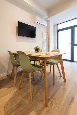 a dining room with a wooden table and green chairs at Lisboa by Concept Flats in Valencia