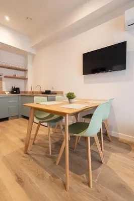 a dining room table with chairs and a television on the wall at Lisboa by Concept Flats in Valencia