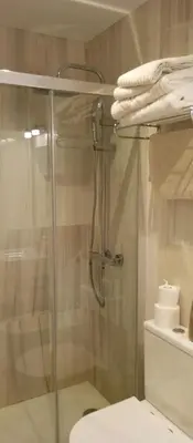 a bathroom with a glass shower with a toilet at Apartamentos PADRE LUIS in Valencia
