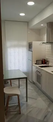 a kitchen with a table and a table and a stove at Apartamentos PADRE LUIS in Valencia