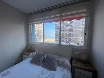 a bedroom with a bed and a large window at Paradise Cullera in Cullera
