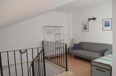 a living room with a couch and a stairway at Arbocer playa Puçol in Puzol
