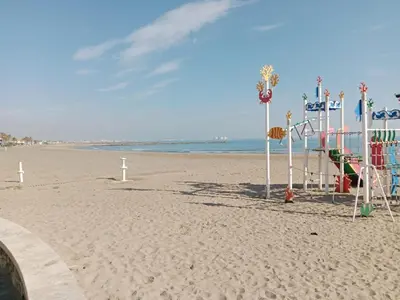 a playground on a beach with the ocean in the background at Arbocer playa Puçol in Puzol