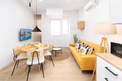 a living room with a yellow couch and a table at Travel Habitat Peset Aleixandre Apartments in Valencia