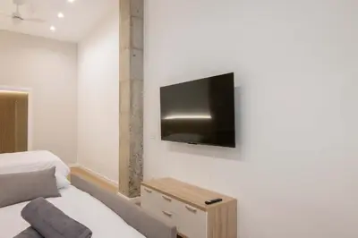 a bedroom with a bed and a tv on the wall at Luxury Apartments Oceanografic in Valencia