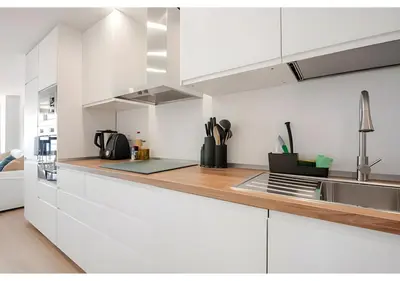 a kitchen with white cabinets and two stools at El Retiro - Frontal al mar, 1a Línea, como en tu casa in Cullera