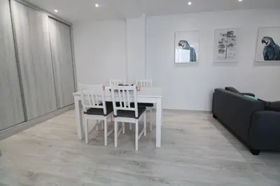 a white dining room table with two chairs and a couch at Vacansis Apartamento Malvarrosa in Valencia