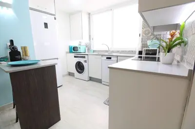 a white kitchen with a washer and dryer at Vacansis Apartamento Malvarrosa in Valencia