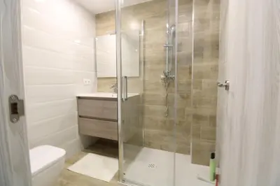 a bathroom with a glass shower with a toilet at Vacansis Apartamento Malvarrosa in Valencia