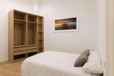 a white bedroom with a bed and a cabinet at Luxury Apartment Oceanografic 6 pax in Valencia