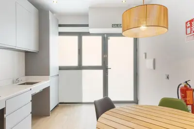 a kitchen and dining room with a wooden table and chairs at Turía Flats by Nomad Host in Valencia