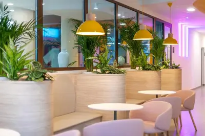 a restaurant with tables and chairs and potted plants at NIDO Malvarrosa Hotel - Apartamento in Valencia