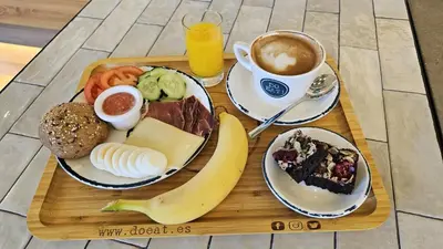 a tray of breakfast foods and a cup of coffee at NIDO Malvarrosa Hotel - Apartamento in Valencia