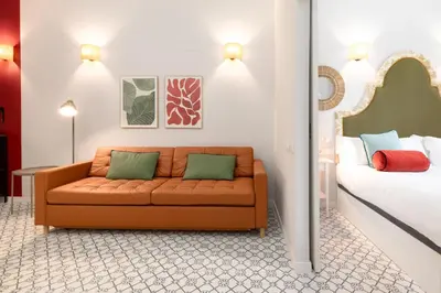 a living room with a couch next to a bed at The Little Village Apartments in Valencia