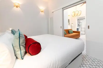a bedroom with a white bed with red pillows at The Little Village Apartments in Valencia