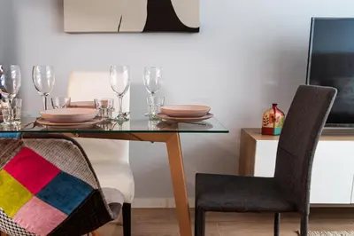 a dining room table with plates and glasses on it at Cozy Suite next to Plaza del Ayuntamiento in Valencia