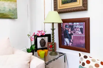 a living room with a table with a lamp and pictures at Cozy Suite next to Plaza del Ayuntamiento in Valencia