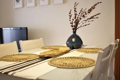 a dining room table with plates and a vase on it at Vacansis Apartamento Florazar 2, 4 in Cullera